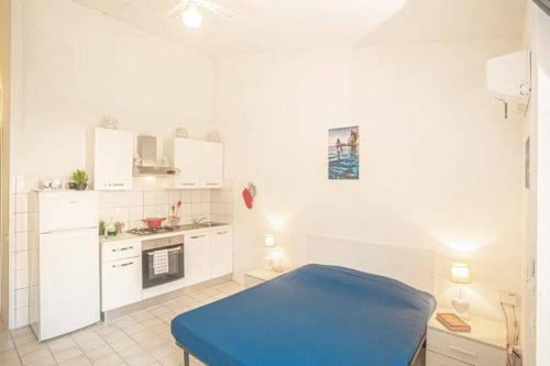 eine weiße Küche mit einem blauen Bett in einem Zimmer in der Unterkunft Pesciolino Bianco in Campese