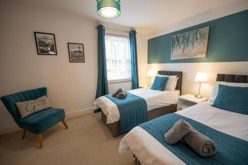 um quarto de hotel com duas camas e uma cadeira em The Marlowe - Beautiful house in the heart of Canterbury with Free Parking em Canterbury