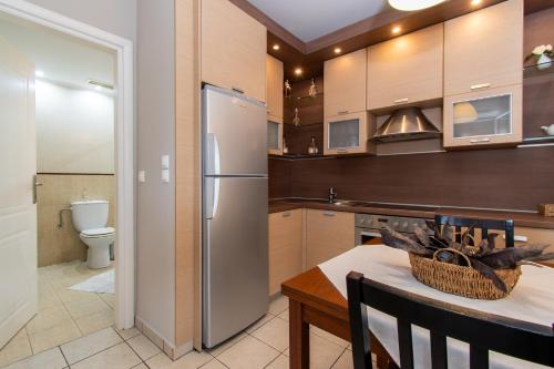 a kitchen with a stainless steel refrigerator and a table at Cristina Apartment 2 in Neos Marmaras