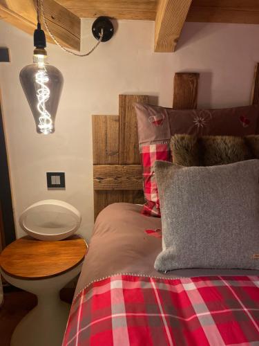 a bedroom with a bed with a plaid blanket at Chalet savoyard d'exception avec piscine chauffée in Bourg-Saint-Maurice