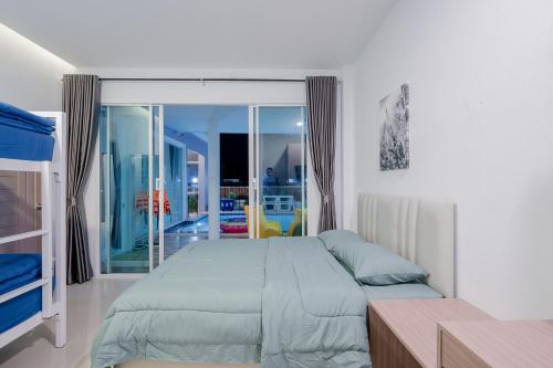 1 dormitorio con 1 cama grande y balcón en พลอยพูลวิลล่า ชะอำ 1 Ploy Poolvilla Cha-am 1 en Cha Am