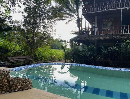 a swimming pool in front of a house at Utria hostel in El Valle