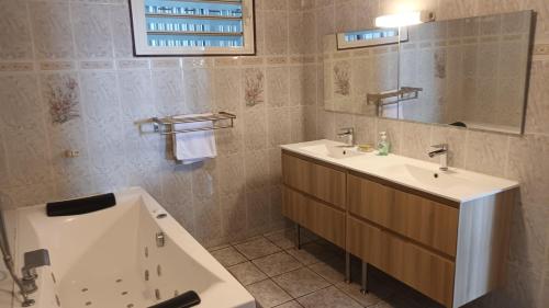 een badkamer met een wastafel en een bad naast een bad bij VACANCES OUEST REUNION in La Possession