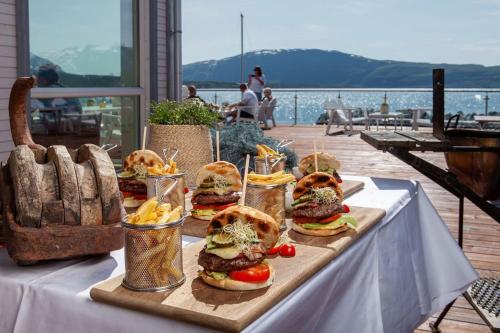 ein Tablett mit Sandwiches auf einem Tisch mit Blick auf das Wasser in der Unterkunft Luksus panorama hytte -H25 in Mestervik