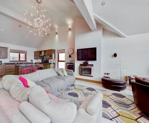 a large living room with a couch and a tv at Atlantic View Coach House - tourist board approved in Portstewart