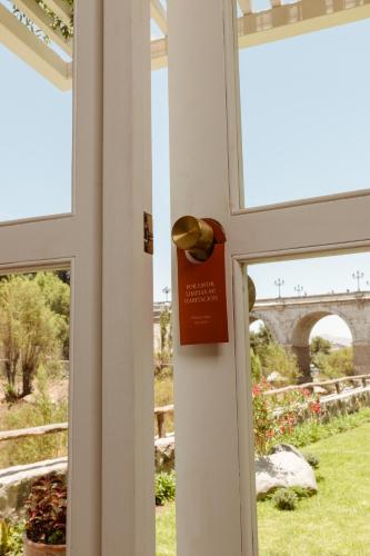 a door with a sign on it next to a window at La Posada del Puente in Arequipa