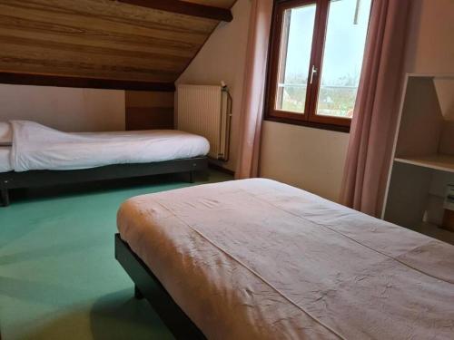 a bedroom with two beds and a window at Maison de Campagne Les Oyats in Quend