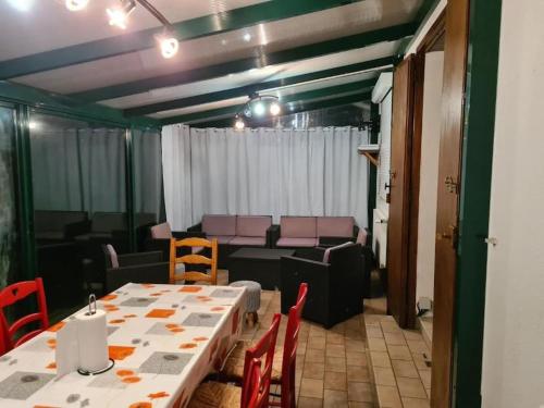 une pièce avec une table, des chaises et un canapé dans l'établissement Maison de Campagne Les Oyats, à Quend