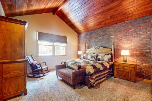 a bedroom with a bed and a brick wall at Northstar Townhome Unit 1968 in Keystone
