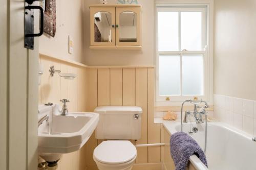 a bathroom with a toilet and a sink and a tub at Portloe Cottage Padstow in Padstow