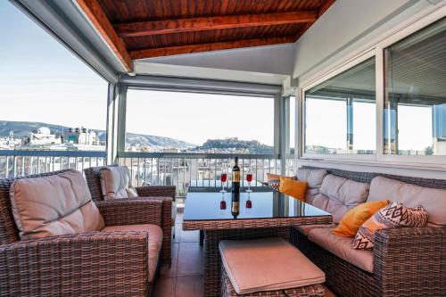 a screened in porch with wicker furniture and a table at PANORAMIC SUITE in Athens