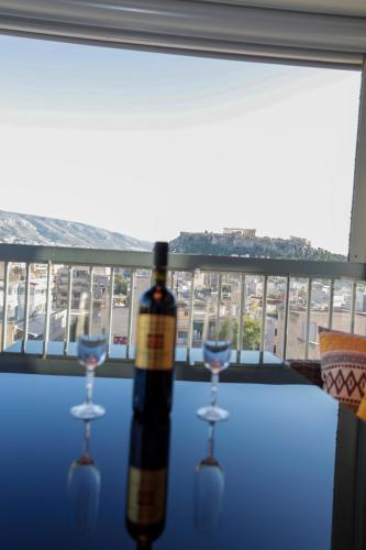 a bottle of wine sitting on a table with two glasses at PANORAMIC SUITE in Athens