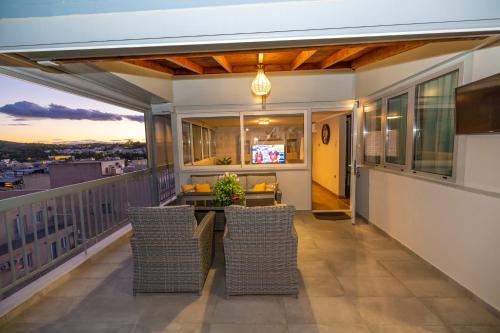a patio with a table and chairs on a balcony at PANORAMIC SUITE in Athens