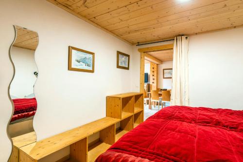 a bedroom with a red bed and a desk at Chalet savoyard d'exception avec piscine chauffée in Bourg-Saint-Maurice