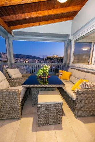 a screened in porch with a table and wicker furniture at PANORAMIC SUITE in Athens