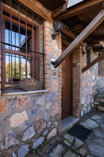 a stone building with a window and a wooden door at Fanis & Lena in Palaios Agios Athanasios