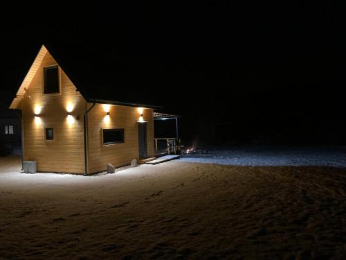 a building with lights on the side of it at night at Domek nad rzeką in Wierzchlas
