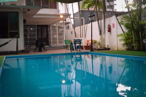 a swimming pool in front of a house at Hostal Loco Coco Loco in Panama City