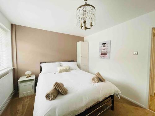 - une chambre avec un grand lit blanc et un lustre dans l'établissement Luxury 4 Bedroom Holiday Home, à Baguley
