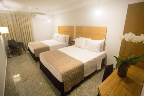una habitación de hotel con dos camas y una mesa en Regency Copacabana Hotel, en Río de Janeiro