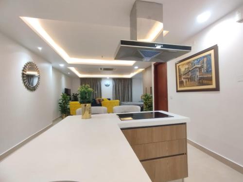 a kitchen with a sink and a living room at Luxury one bed Apartment in Gold Crest Mall And Residency DHA Lahore in Lahore