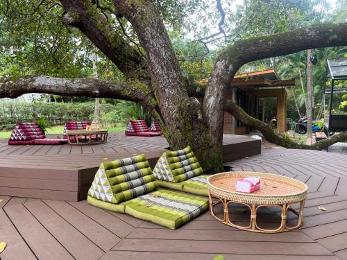 a patio with a tree with couches and a table at Coffee and Resort in Ko Phayam