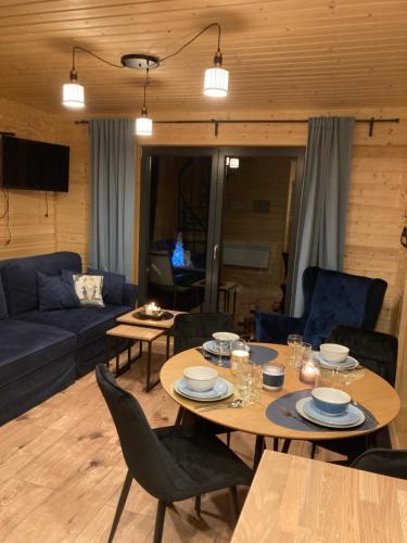 a living room with a table and a blue couch at Domek nad rzeką in Wierzchlas