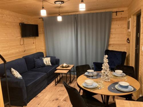 a living room with a blue couch and a table at Domek nad rzeką in Wierzchlas