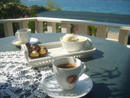a table with a cup of coffee and a tray of food at Apartments Villa Iva Alla in Trogir