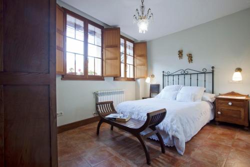 1 dormitorio con 1 cama, 1 silla y 1 mesa en Apartamentos Casa María Juanín, en Collanzo