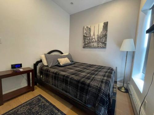 niewielka sypialnia z łóżkiem i lampką w obiekcie Modern 1-bedroom in Manhattan-New York, NY w Nowym Jorku