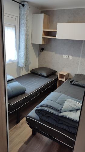 une chambre avec deux lits et une fenêtre dans l'établissement Les Dunes de Contis, à Saint-Julien-en-Born