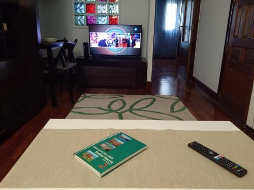 a book and a remote control sitting on a table at Apartamento Etxe Morea, Casco Histórico in Bermeo