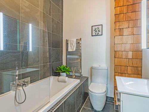 a bathroom with a tub and a toilet and a sink at 2 bed in Harrogate 87817 in Harrogate