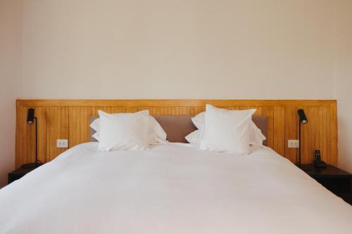 a large white bed with white sheets and pillows at La Posada del Puente in Arequipa