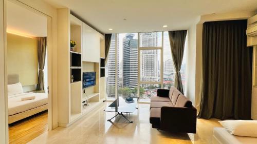 uma sala de estar com um sofá e uma grande janela em The Platinum Suites KLCC em Kuala Lumpur