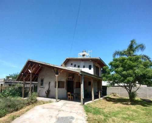 ein kleines weißes Haus mit einem Baum davor in der Unterkunft Casa ecológica in Funes