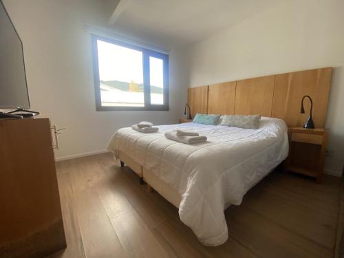 1 dormitorio con 1 cama blanca grande y ventana en Alamos de los Andes ExtraL - Andarlibre en San Martín de los Andes