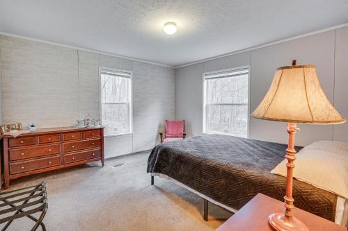 a bedroom with a bed and a dresser and a lamp at Pet-Friendly Home about 10 Mi to Hocking Hills! in South Bloomingville
