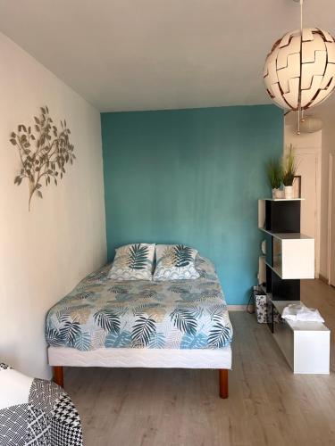 a bedroom with a bed and a blue wall at Studio 30 m2 cocooning Timone Marseille in Marseille