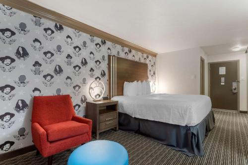 Pokój hotelowy z łóżkiem i czerwonym krzesłem w obiekcie Aiden by Best Western Austin City Hotel w mieście Austin