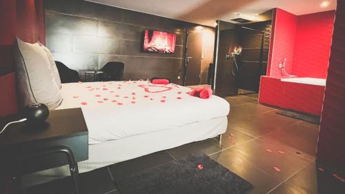 a bedroom with a bed with red rose petals on the floor at Le Confiden'spa Loft 55m2 Jacuzzi - Billard - Cheminée - Terrasse in Hoenheim