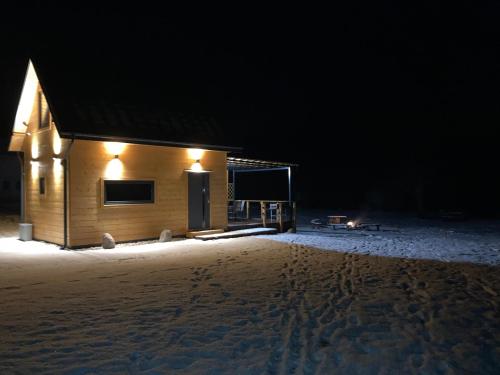 a cabin in the snow at night at Domek nad rzeką in Wierzchlas