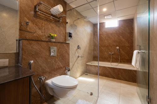 a bathroom with a toilet and a glass shower at Malnad Shire Eco Resort in Shimoga