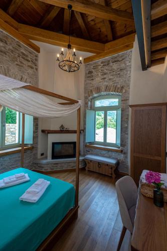 a bedroom with a bed and a fireplace at Nostos Country House in Tsagarada