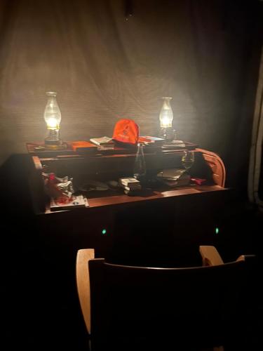 a table with two lights and a chair in a dark room at Out in Africa Wildlife Lodge in Dinokeng Game Reserve