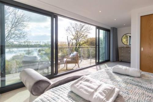 een slaapkamer met een bed en een groot raam bij The Lookout LR11 Lakeside Spa Holidays in Somerford Keynes