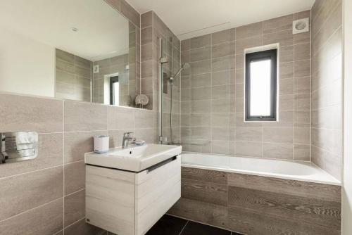 een badkamer met een wastafel en een bad bij The Lookout LR11 Lakeside Spa Holidays in Somerford Keynes
