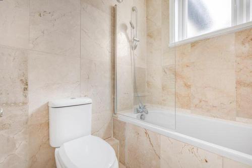 a bathroom with a toilet and a shower and a tub at Magnificent 5 bedrooms London house in Bromley