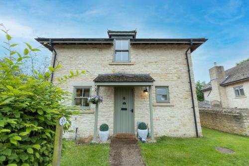 an old brick house with a green door at Badgers Lodge MV37 Lakeside Spa Property in Somerford Keynes